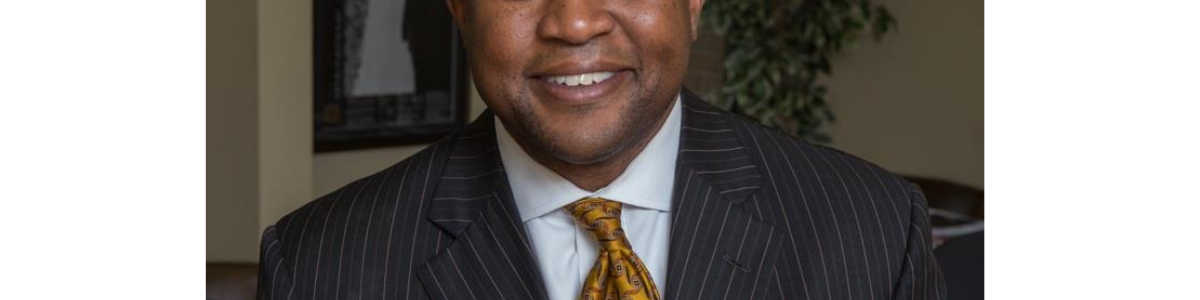 Darrin Thomas in dark suit and rust-colored tie.