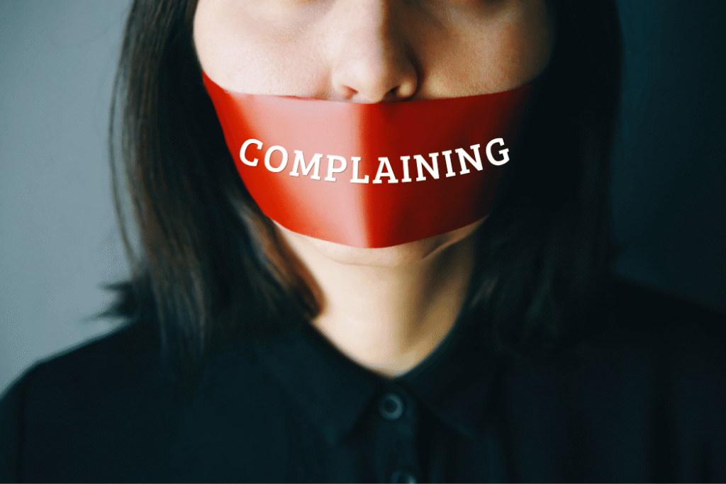 Business woman headshot with red tape over her mouth that says COMPLAINING