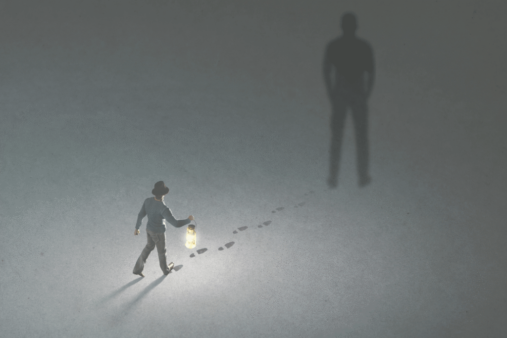 Small figure walking towards large shadow