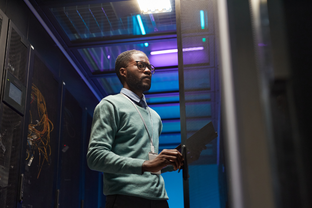 Young Black man stands in front of large computer