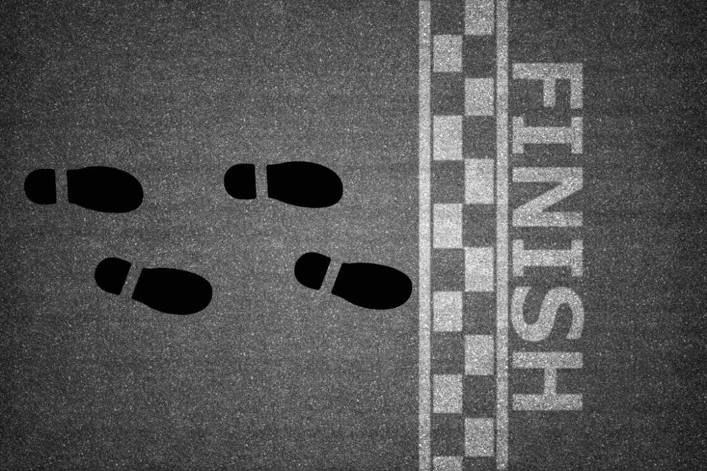 Four sets of footprints standing at finish line