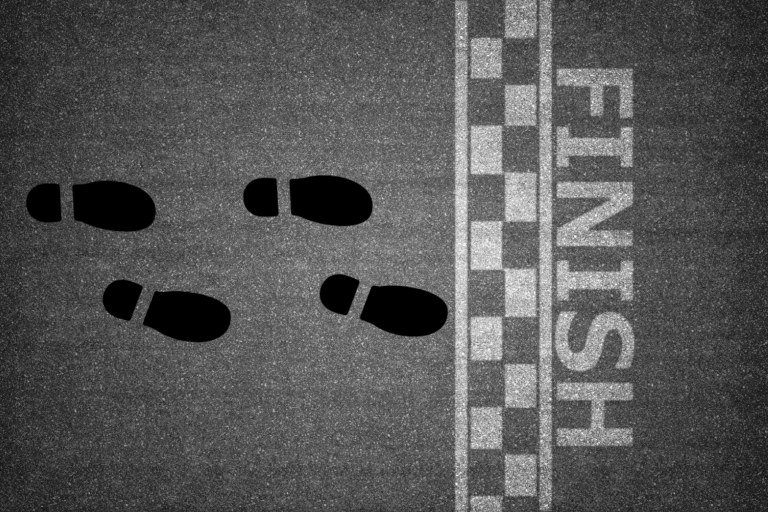 Four sets of footprints standing at finish line