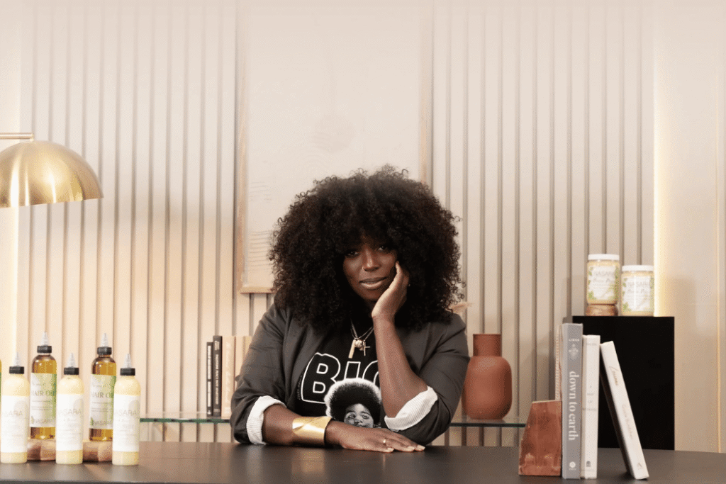 Khy Elijah sitting at her desk with Nasara Organics products to her side