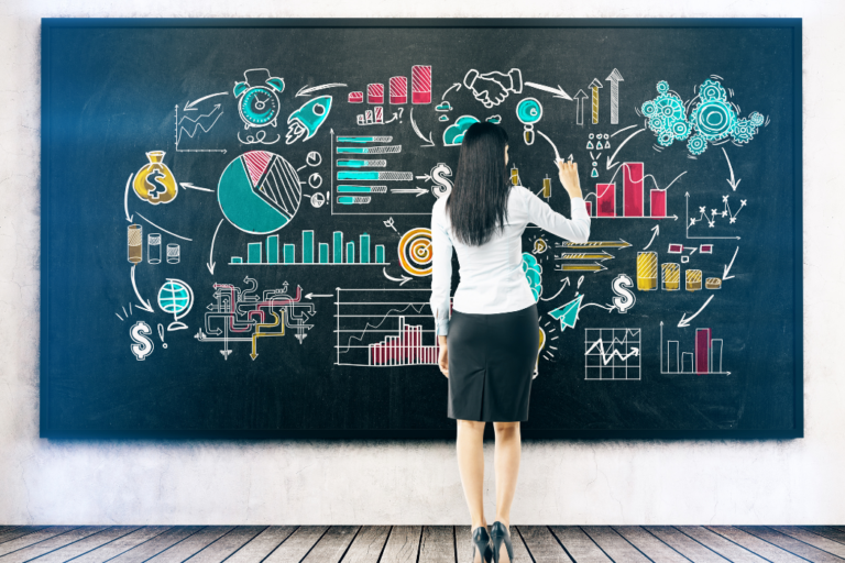 Woman standing at blackboard with her back to the camera.