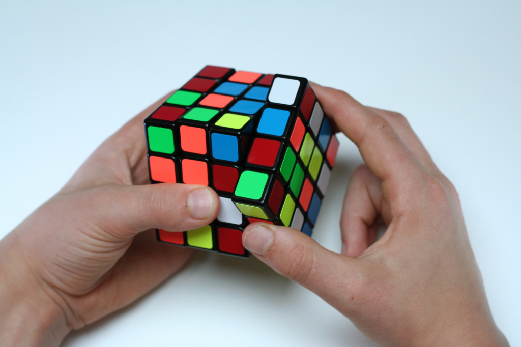 Man's hands completing a Rubik's Cube