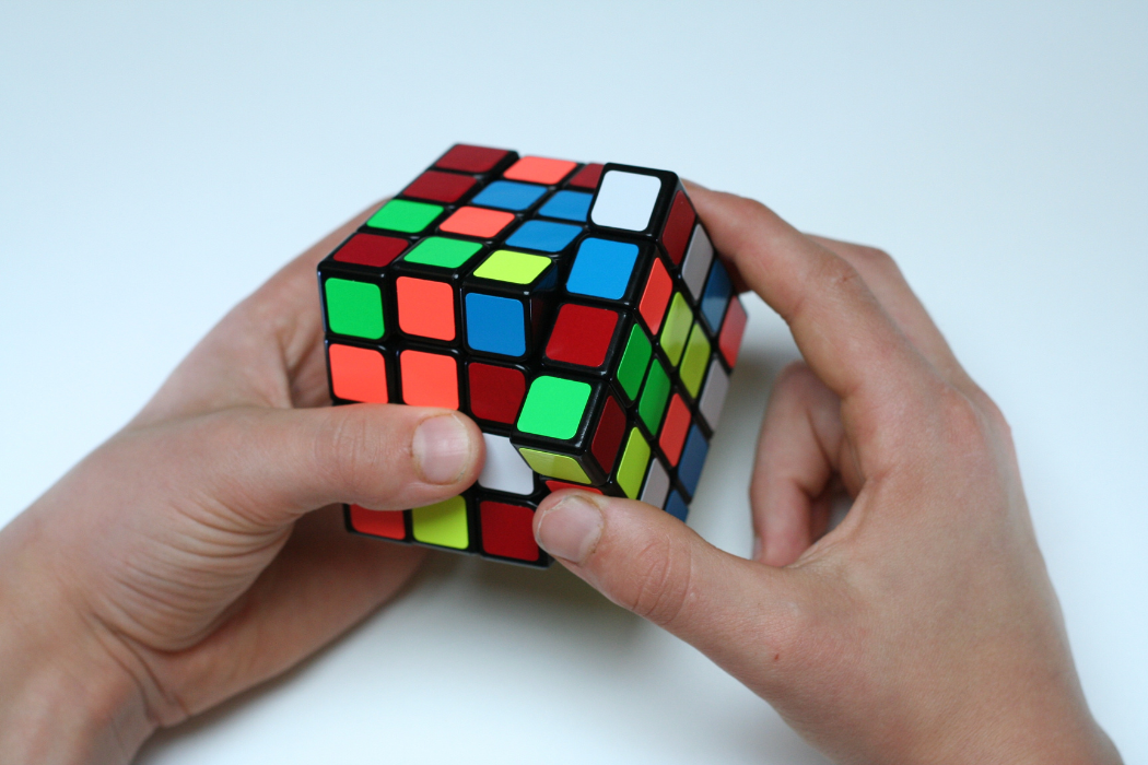 Man's hands completing a Rubik's Cube