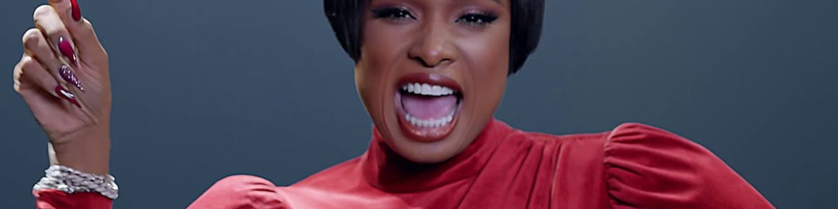 Black woman with bob wig in a red dress singing