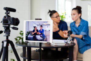 Asian woman and main filming video on a laptop