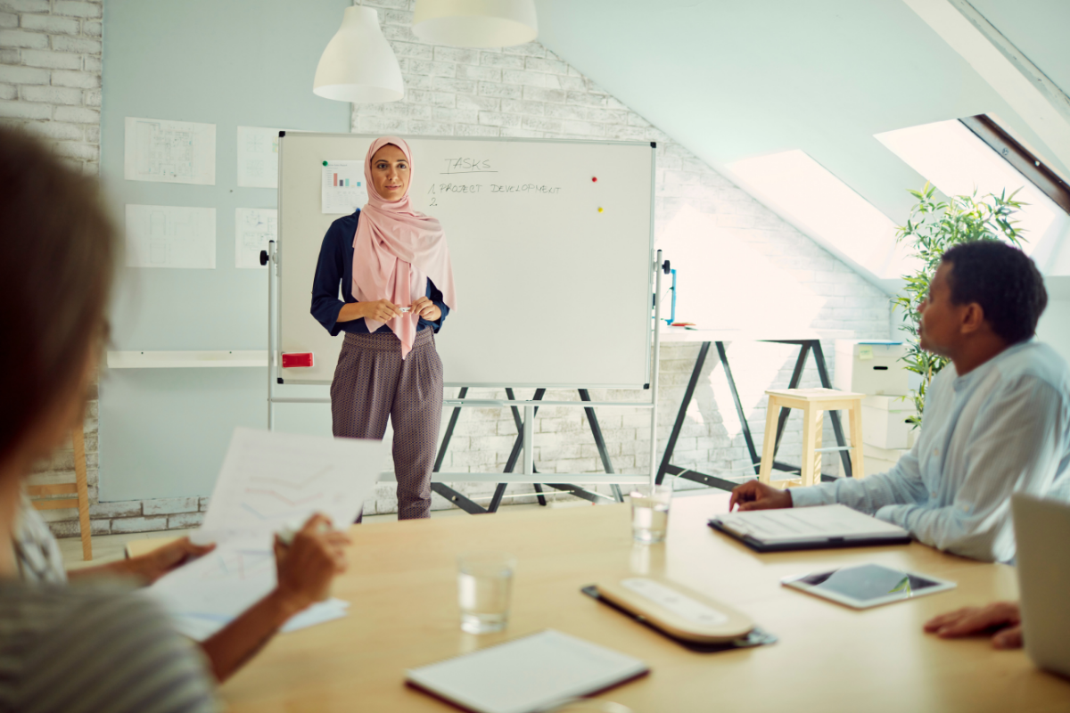 Muslim woman standing in front of whiteboard